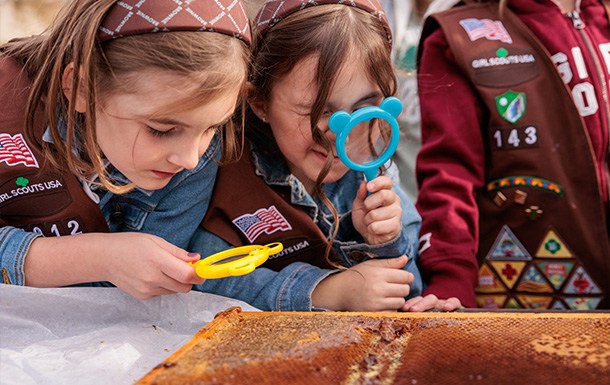 Girl Scouts look through magnifying glasses for a badge activity