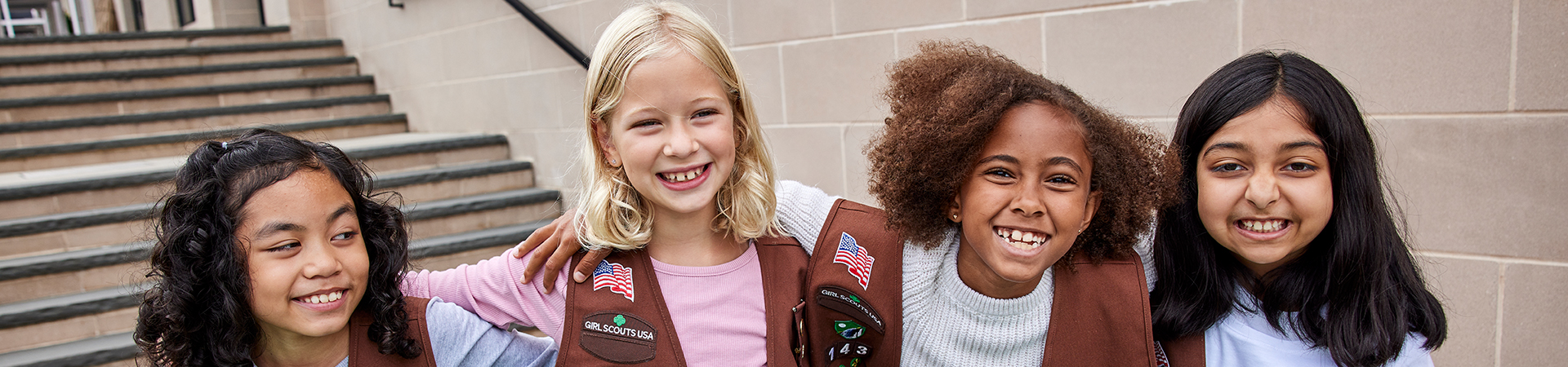  smiling group of diverse girl scouts outside 