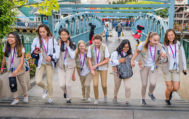 Girl Scouts walking together across a bridge in a foreign country