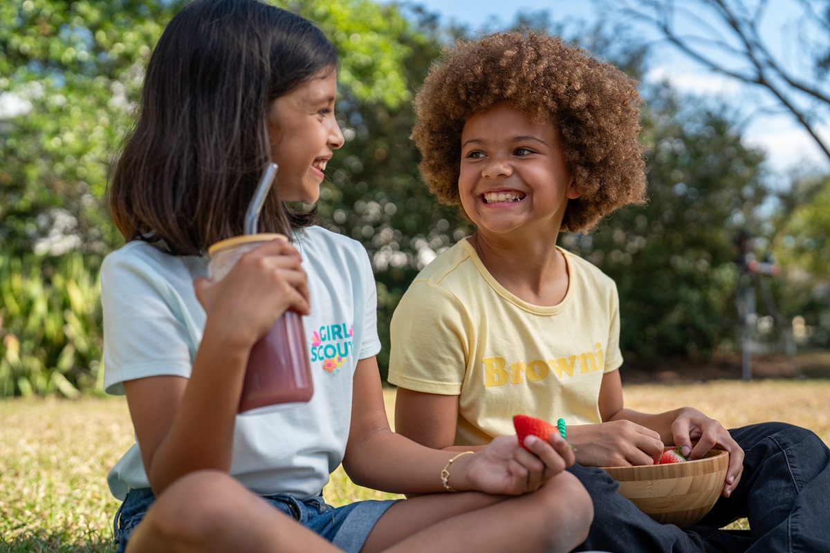 girls sitting outside together having a healthy snack