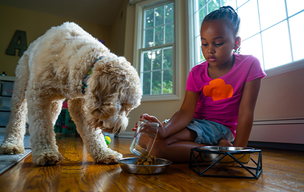 Girl Scout sits indoors with a dog