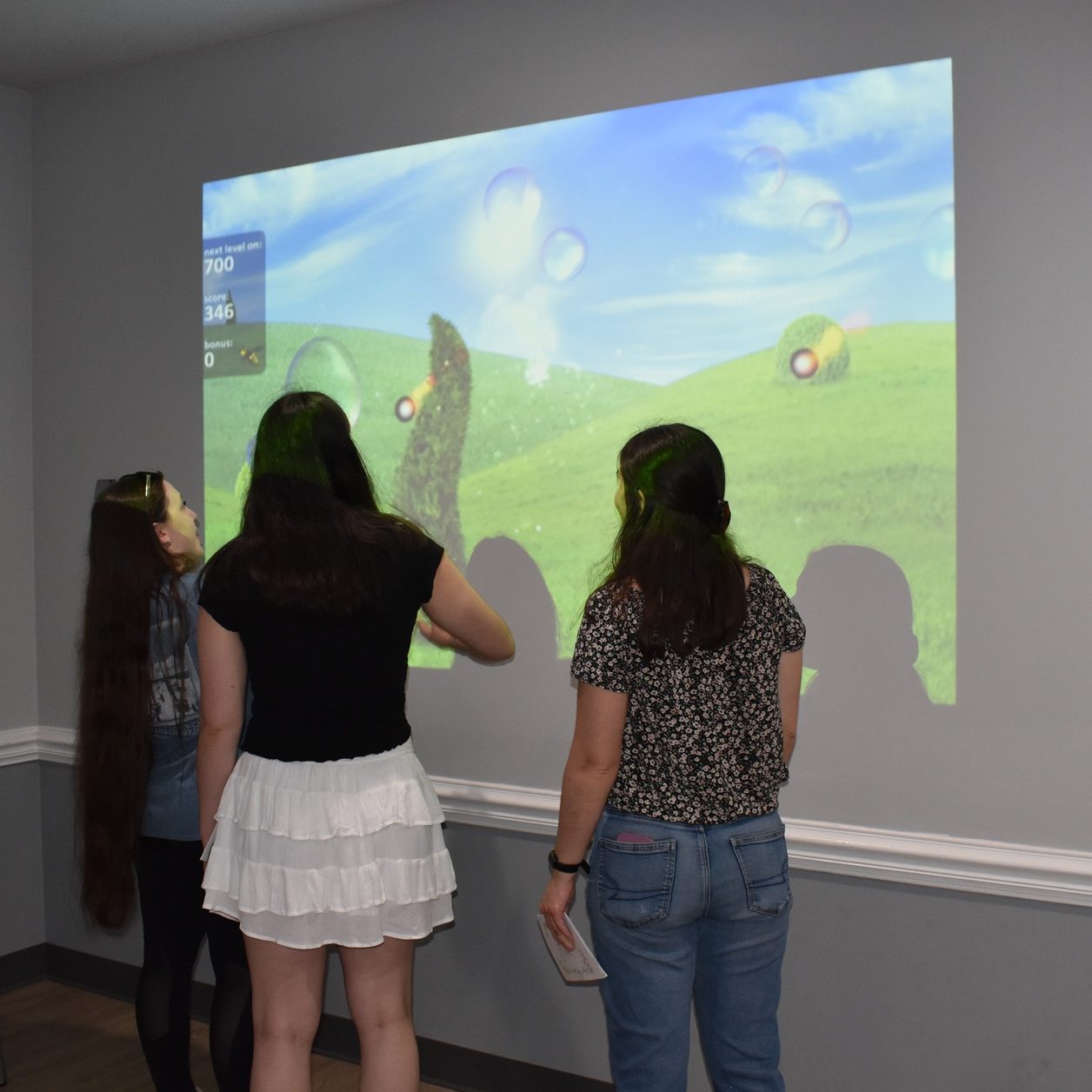 older Girl Scouts interact with the Eyeclick OBIE Projector