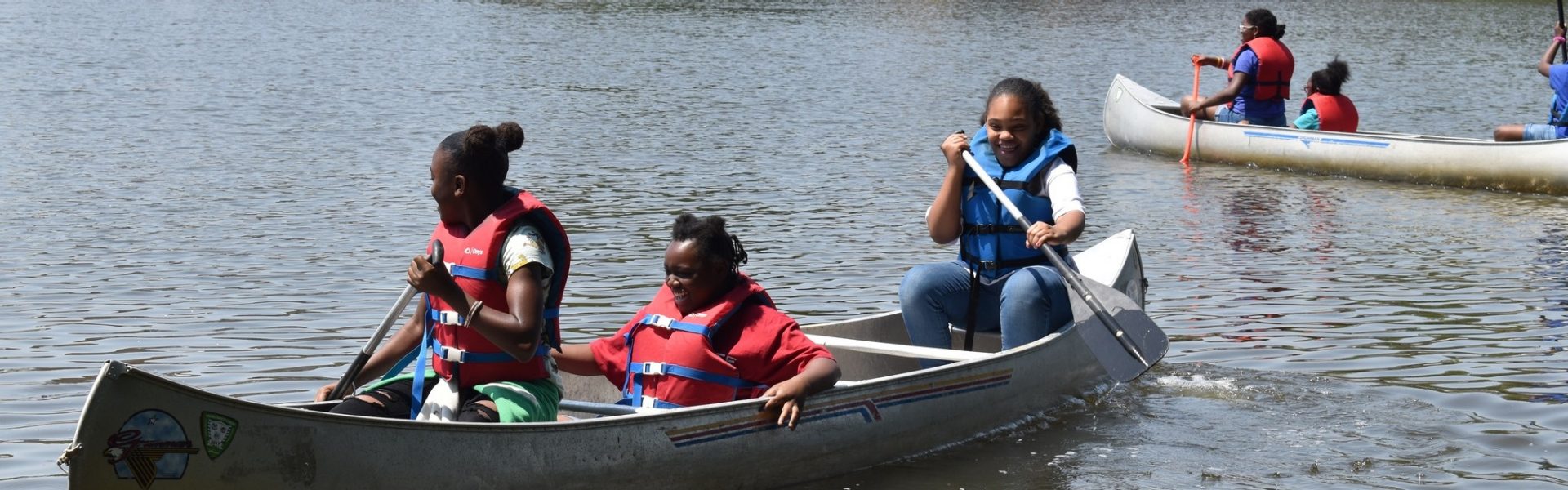  Girl Scouts outdoors at summer camp, laughing together 