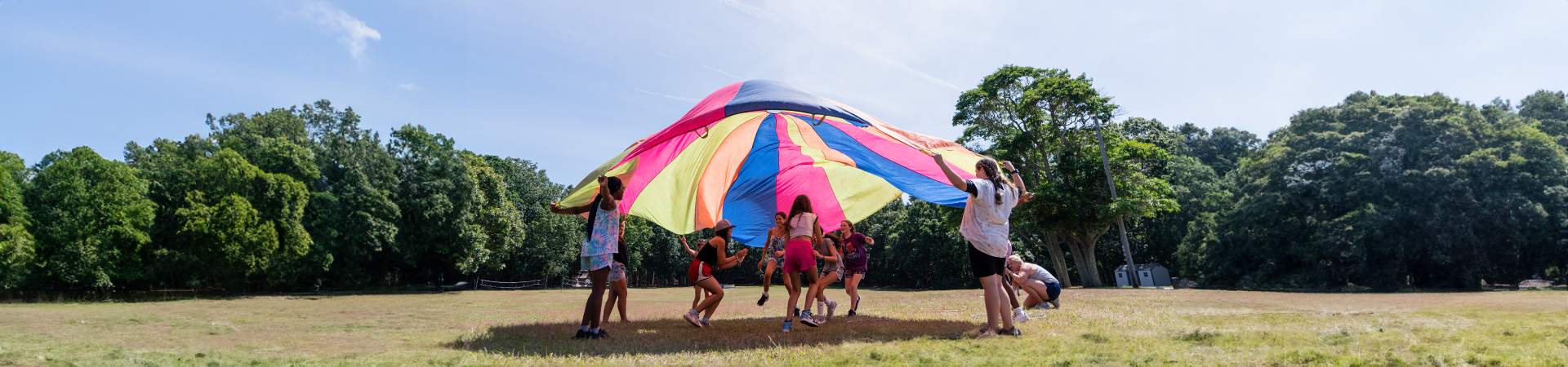  Girl Scouts outdoors at summer camp, laughing together 
