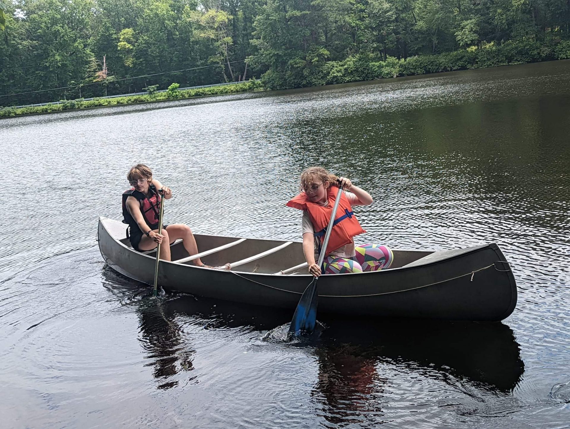  Girl Scouts paddle a canoe at Burke's Mill Pond 