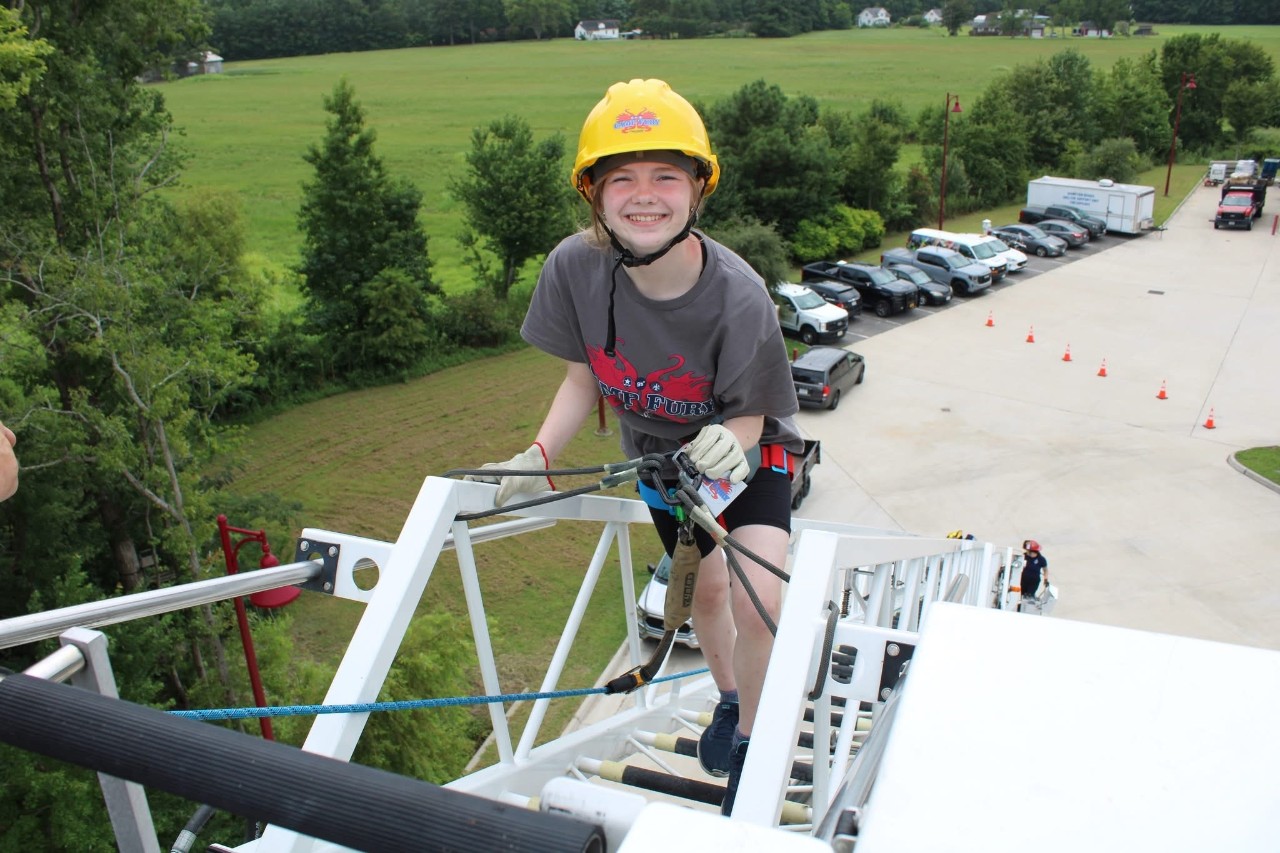 Girl Scout Senior Brianna climbs an 80-foot ladder on a fire truck