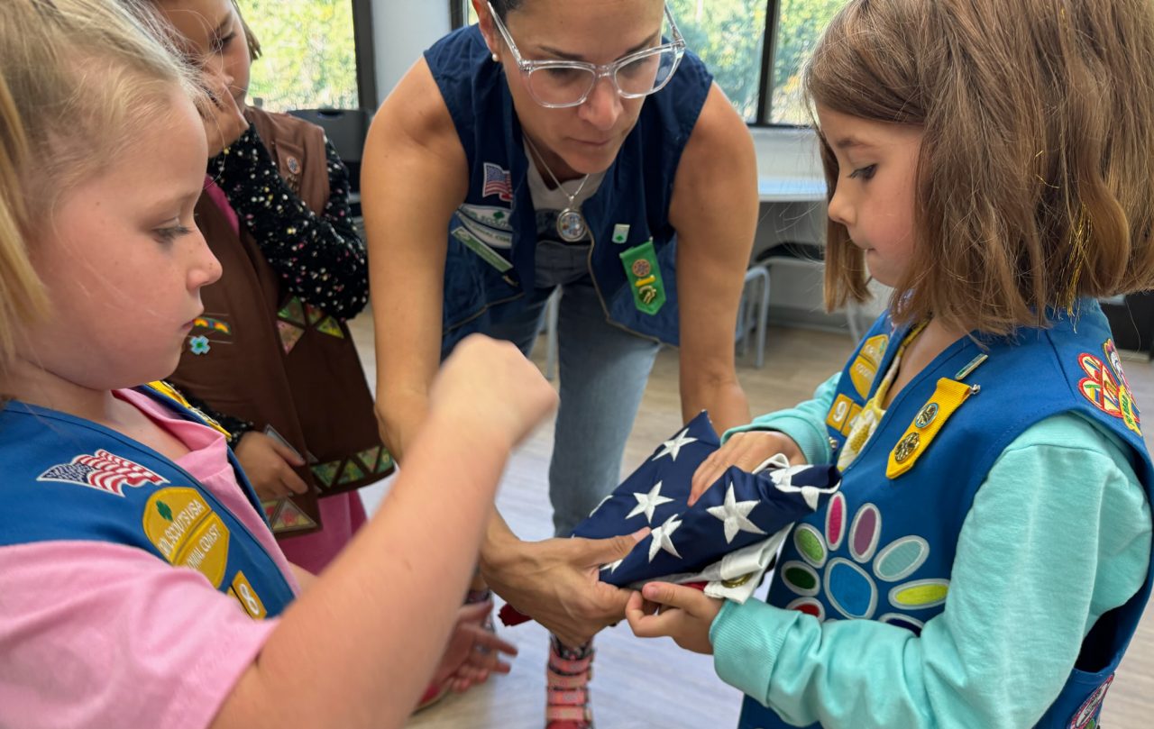 Terra Gray teaches Girl Scouts how to fold an American Flag