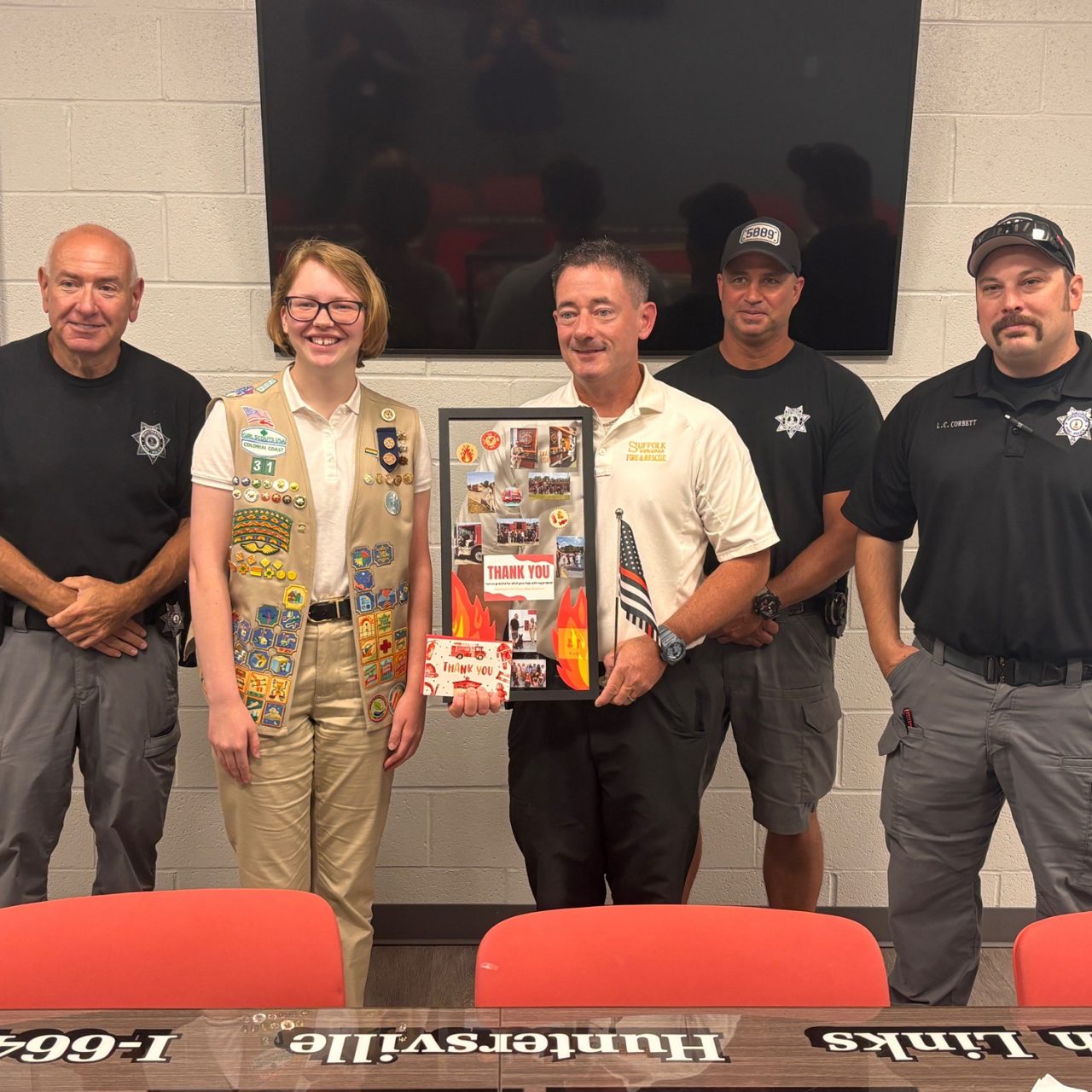 Gold Award Girl Scout Aliya presented thank you gifts to Suffolk Fire and Rescue for their support of her project