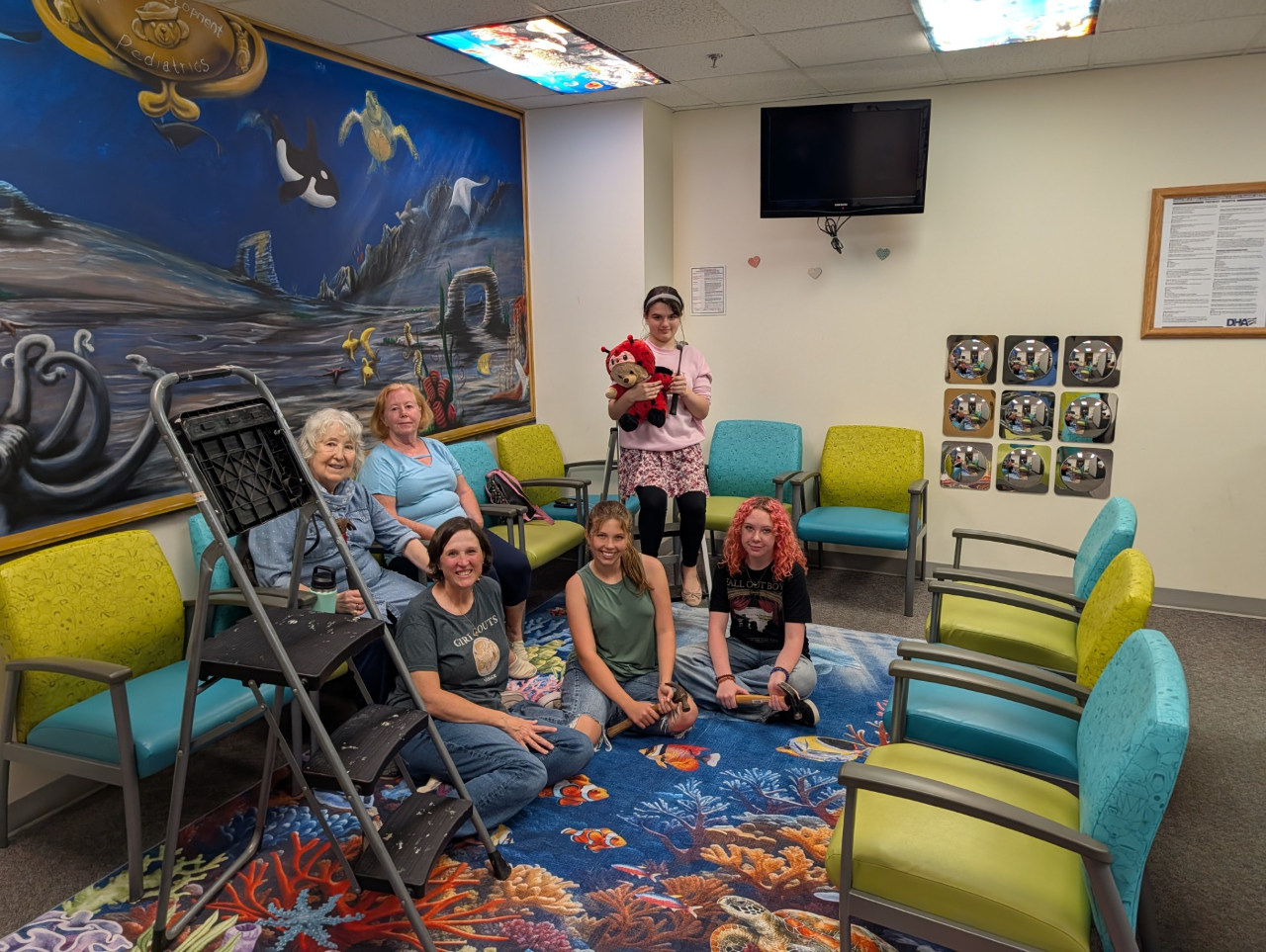 Left to Right: on the couch, Helene Monteil (Lily's grandmother) and Cathy Hayes (Laila's grandmother) who came to help with installation; seated, Girl Scout volunteer Danielle Monteil, Girl Scout Cadettes Lily M. and Laila H.; standing, Girl Scout Cadette Olivia G.