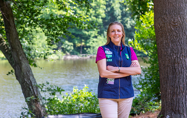 Girl Scout Volunteer in uniform standing outdoors and smiling