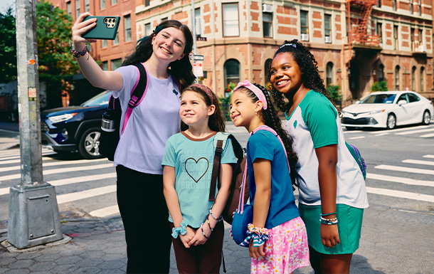 Girl Scouts of various ages taking a selfie while out together on a day trip