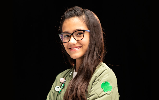 Portrait of a Girl Scout with long hair wearing glasses and smiling