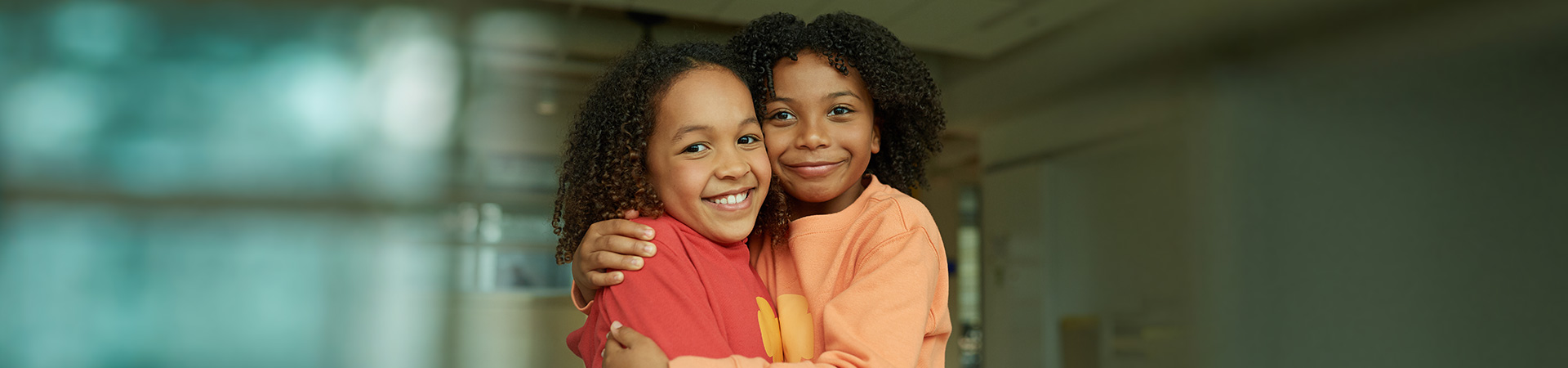 Girl Scouts hugging and smiling indoors classroom 
