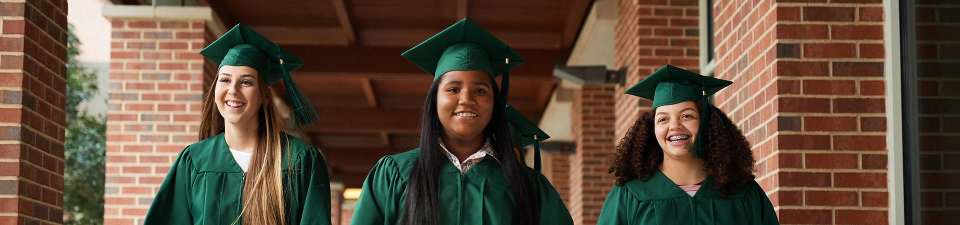  smiling high school graduates in cap and gown 