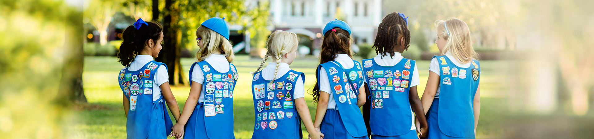  Girl Scout Brownie showing the back of her vest with fun patches 
