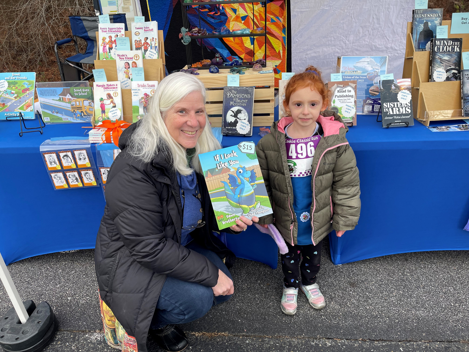 Dawn Brotherton at her book display with a Girl Scout Daisy