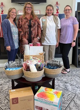 Girl Scout Troop 726 Cadette Maggie C., second from right, poses with representatives of Tidewater Petroleum, a company donating the materials pictured to support the efforts of three Girl Scouts (Addie M., Theresa A. and Maggie C.) to aid Windsor Grove residents. Pictured are, from left, Erica Callow, Ellen Rice, Maggie C. and Shirlee Luter. (Photo submitted by Sharon Cook)