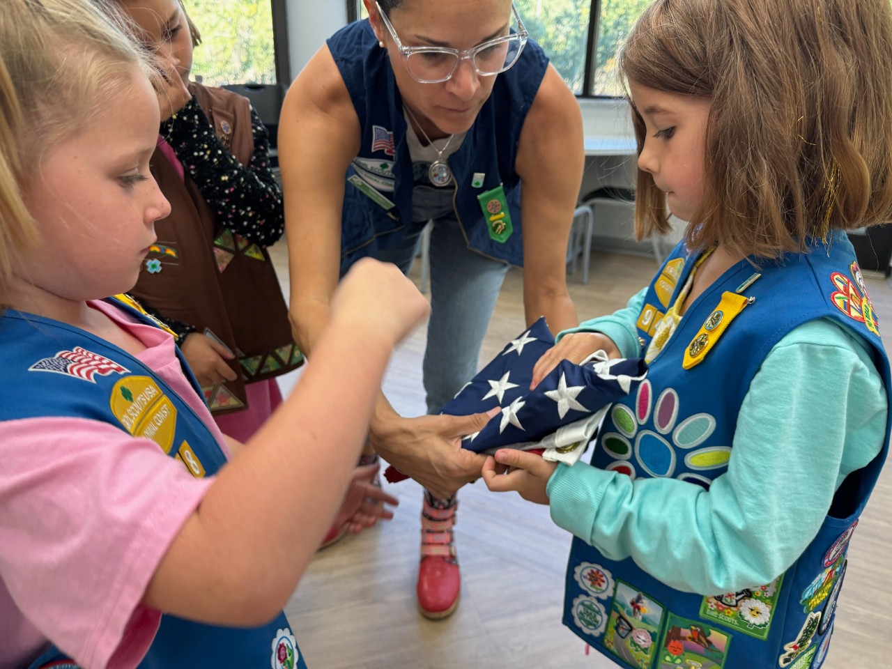 Terra Gray teaches Girl Scouts how to fold an American flag.