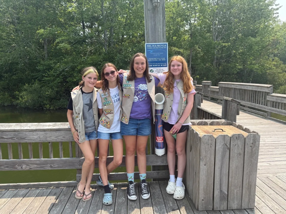 From left: Wren, Piper, Abigail and Emma, members of Girl Scout Troop 1385, stand in front of one of the fishing line recycling tubes they installed at Waller Mill Park. (Skylar Hartgerink/The Virginia Gazette)